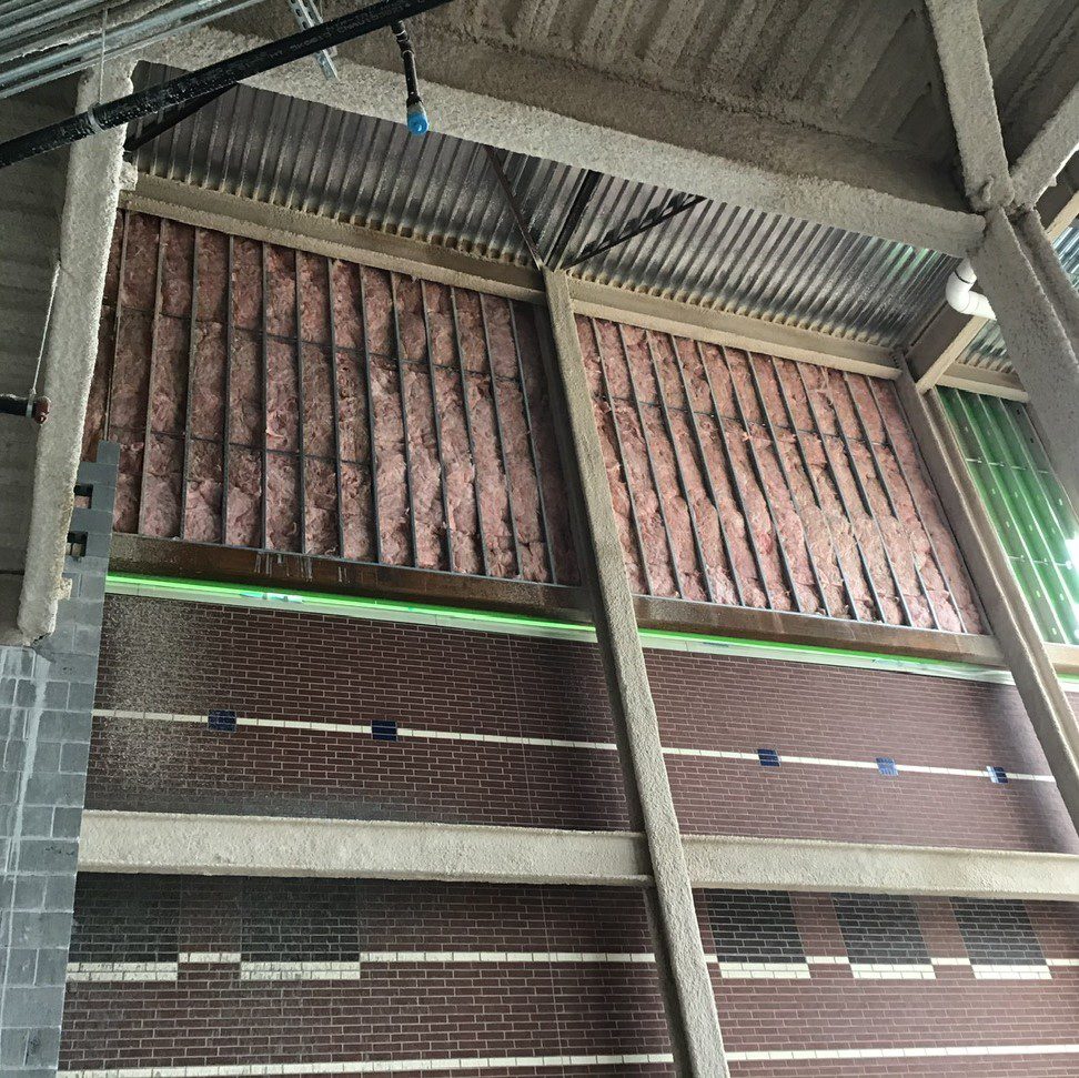 Exposed insulation on unfinished building wall.